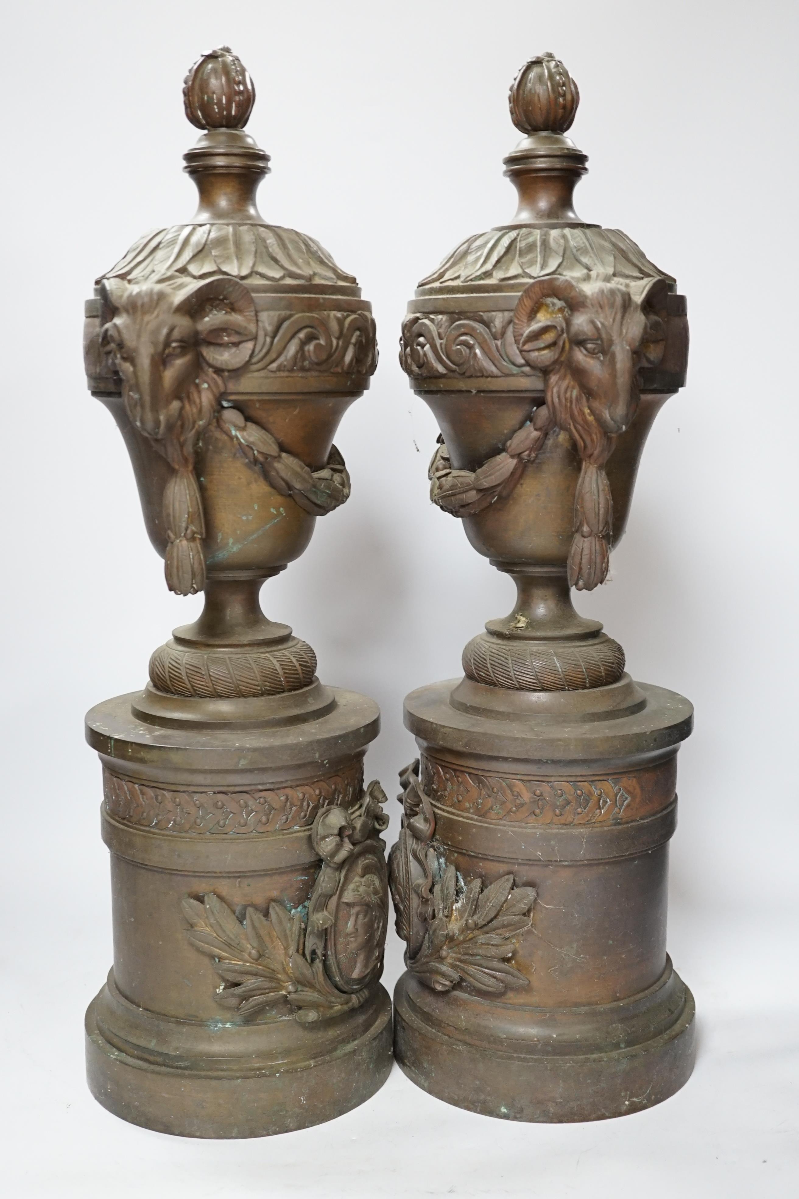 A pair of bronze urns with rams head, Roman mask and swag decoration, 53cm high